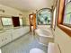 Well-lit bathroom featuring a jacuzzi tub and double sink vanity with bright, tropical decor at 610 Coolsprings Ln, Woodstock, GA 30188