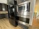 Contemporary kitchen appliances including a stainless steel microwave, built in oven, and a sleek black refrigerator at 610 Coolsprings Ln, Woodstock, GA 30188