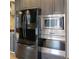 Contemporary kitchen appliances including a stainless steel microwave, built in oven, and a sleek black refrigerator at 610 Coolsprings Ln, Woodstock, GA 30188