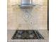 Modern kitchen cooktop with a sleek stainless steel range hood and intricate backsplash, combining style and functionality at 610 Coolsprings Ln, Woodstock, GA 30188