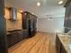 Modern kitchen with sleek, dark cabinets, stainless steel appliances, and light wood-look flooring at 610 Coolsprings Ln, Woodstock, GA 30188