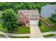 An aerial shot of a well-maintained two-story home with a neatly landscaped lawn in a lush, green neighborhood at 1727 Shire Village Dr, Sugar Hill, GA 30518