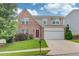 Charming two-story home with brick and siding exterior, well-maintained lawn, and an attached two-car garage at 1727 Shire Village Dr, Sugar Hill, GA 30518