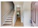 Bright foyer featuring hardwood floors, staircase with white railing, and a view into the dining area at 1727 Shire Village Dr, Sugar Hill, GA 30518