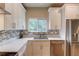 Bright kitchen features stainless steel appliances, white cabinets, and a lovely mosaic tile backsplash at 1727 Shire Village Dr, Sugar Hill, GA 30518