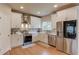 Bright kitchen with white cabinets, stainless steel appliances, and hardwood floors with an island and hood vent at 1727 Shire Village Dr, Sugar Hill, GA 30518