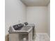 Convenient laundry room featuring stainless steel, front-load washer and dryer at 1727 Shire Village Dr, Sugar Hill, GA 30518