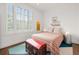 Bright bedroom featuring a vintage trunk, vibrant rug, and large window with plantation shutters at 422 Bill Kennedy Se Way, Atlanta, GA 30316