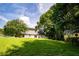 Backyard with expansive lawn, mature trees, wooden fencing, and storage building with french doors at 5427 Highway 81, Loganville, GA 30052