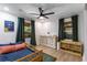Sunlit bedroom with wood-look floors, a modern ceiling fan, and ample space for relaxing and playing at 5714 Braddock Ct, Atlanta, GA 30350