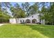 Stunning white home featuring arched front porch, lush lawn, and blooming hydrangea bushes at 5714 Braddock Ct, Atlanta, GA 30350