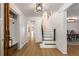 Bright foyer featuring wood floors, white walls, stairs, and modern light fixture at 5714 Braddock Ct, Atlanta, GA 30350
