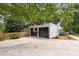 Detached garage featuring black doors, traditional design, complemented by a wooden fence and paved driveway at 5714 Braddock Ct, Atlanta, GA 30350