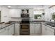 Well-lit kitchen with stainless steel appliances, granite countertops and white cabinets at 5714 Braddock Ct, Atlanta, GA 30350