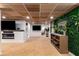 Basement living area with wood ceilings, fireplace and accent plant wall, perfect for relaxation and entertainment at 5714 Braddock Ct, Atlanta, GA 30350
