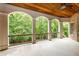 Covered back porch with arched openings overlooking the lush backyard at 930 Shepards Ct, Roswell, GA 30075