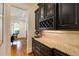 Butler's pantry with dark cabinets, granite countertops, and wine storage, conveniently located near the dining area at 930 Shepards Ct, Roswell, GA 30075