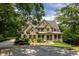 Stately brick and stone home boasts lush landscaping, circular driveway, and covered front porch at 930 Shepards Ct, Roswell, GA 30075