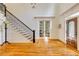 Welcoming foyer with staircase, hardwood floors, and views to the office through glass paneled french doors at 930 Shepards Ct, Roswell, GA 30075