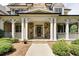 Inviting front porch with stone accents, columns, and a decorative front door at 930 Shepards Ct, Roswell, GA 30075