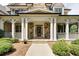 Inviting front porch with stone columns, wooden door, and well-maintained landscaping at 930 Shepards Ct, Roswell, GA 30075