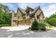 Spacious three-car garage with stone and siding exterior, complemented by mature landscaping at 930 Shepards Ct, Roswell, GA 30075