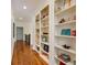 Hallway lined with custom built-in bookshelves featuring hardwood floors at 930 Shepards Ct, Roswell, GA 30075