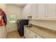 Well-equipped laundry room with a sink, granite counters, washer and dryer, and storage cabinets at 930 Shepards Ct, Roswell, GA 30075