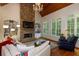 Inviting living room with stone fireplace, built-in shelving, and natural light from large windows at 930 Shepards Ct, Roswell, GA 30075