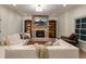 Cozy living room with stone fireplace, built-in bookshelves, hardwood floors, and comfortable seating at 930 Shepards Ct, Roswell, GA 30075