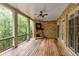 Expansive covered porch featuring a stone fireplace, ceiling fan, and views of a wooded lot at 930 Shepards Ct, Roswell, GA 30075