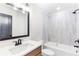 Bathroom showcasing vanity with quartz countertop, a framed mirror, and a tile surround tub at 102 Red Oak Ln, Carrollton, GA 30116