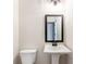 Well-lit half bathroom featuring a pedestal sink and toilet at 102 Red Oak Ln, Carrollton, GA 30116