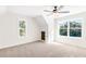 Bright bedroom with plush carpet, ceiling fan, and natural light from two large windows at 102 Red Oak Ln, Carrollton, GA 30116