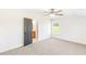 Bedroom with ceiling fan, neutral carpet and walls, window overlooking yard, and an open bathroom doorway at 102 Red Oak Ln, Carrollton, GA 30116