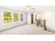 Bright hallway with natural light from a large window, wood and metal staircase, and multiple doorways at 102 Red Oak Ln, Carrollton, GA 30116