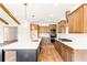 Modern kitchen features an island with pendant lighting, stainless steel appliances, and beautiful wood floors at 102 Red Oak Ln, Carrollton, GA 30116