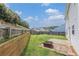 Fenced backyard featuring green lawn, a fire pit, and bordered by trees and shrubbery at 27 Autumn Canyon Se Path, Cartersville, GA 30121