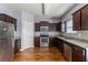 Well-lit kitchen features wood floors, stainless steel appliances, granite countertops and dark wood cabinets at 27 Autumn Canyon Se Path, Cartersville, GA 30121