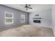 Spacious main bedroom featuring neutral carpet, a ceiling fan, and a decorative fireplace with a mounted TV at 27 Autumn Canyon Se Path, Cartersville, GA 30121