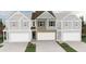 Two-story townhome showing brick and siding, two car garage and landscaping at 438 Lanier Cir, Woodstock, GA 30189