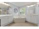 Bathroom features a soaking tub, double sinks and a large mirror at 550 Vinings Springs Se Dr, Smyrna, GA 30126