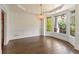 Light-filled dining room with hardwood floors, tray ceilings, large windows, and stylish chandelier at 550 Vinings Springs Se Dr, Smyrna, GA 30126