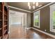 Inviting living room boasts a modern chandelier, large windows, and gleaming hardwood floors at 550 Vinings Springs Se Dr, Smyrna, GA 30126
