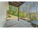 Spacious outdoor patio with concrete flooring, providing a tranquil view of the lush, wooded backyard at 550 Vinings Springs Se Dr, Smyrna, GA 30126