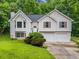 Charming two-story home featuring a well-maintained lawn and a two-car garage, nestled amongst mature trees at 87 Fair Havens Dr, Hiram, GA 30141