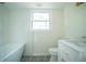 A bright bathroom with a soaking tub, subway tile, and black and white patterned flooring at 2524 Glenrock Dr, Decatur, GA 30032