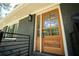 Close-up of wooden front door with glass panels, dark gray brick and modern railings at 2524 Glenrock Dr, Decatur, GA 30032