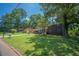 Well-maintained front yard with mature trees surrounding a one-story brick home at 2524 Glenrock Dr, Decatur, GA 30032