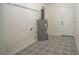 Functional laundry area with patterned flooring, water heater, and easy access to outside at 2524 Glenrock Dr, Decatur, GA 30032